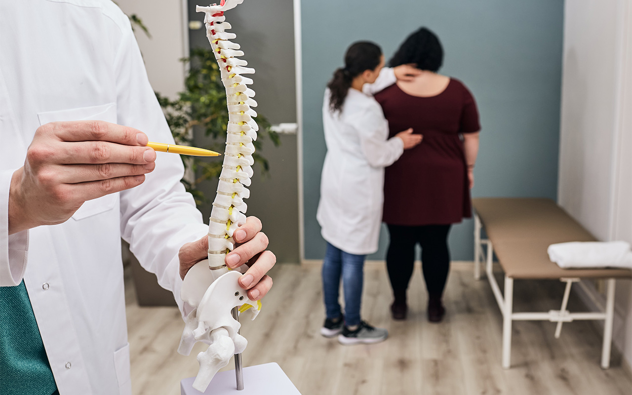 Medico analisando coluna vertebral. Site Dr. Marcio Penna - Médico Ortopedista Cirurgião de Coluna - Belém (PA)